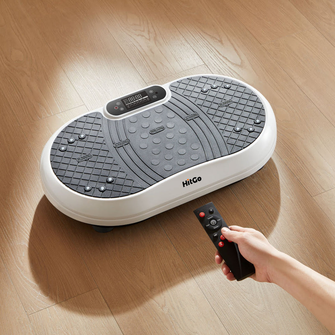 Vibration plate platform on wood floor with hand holding remote.