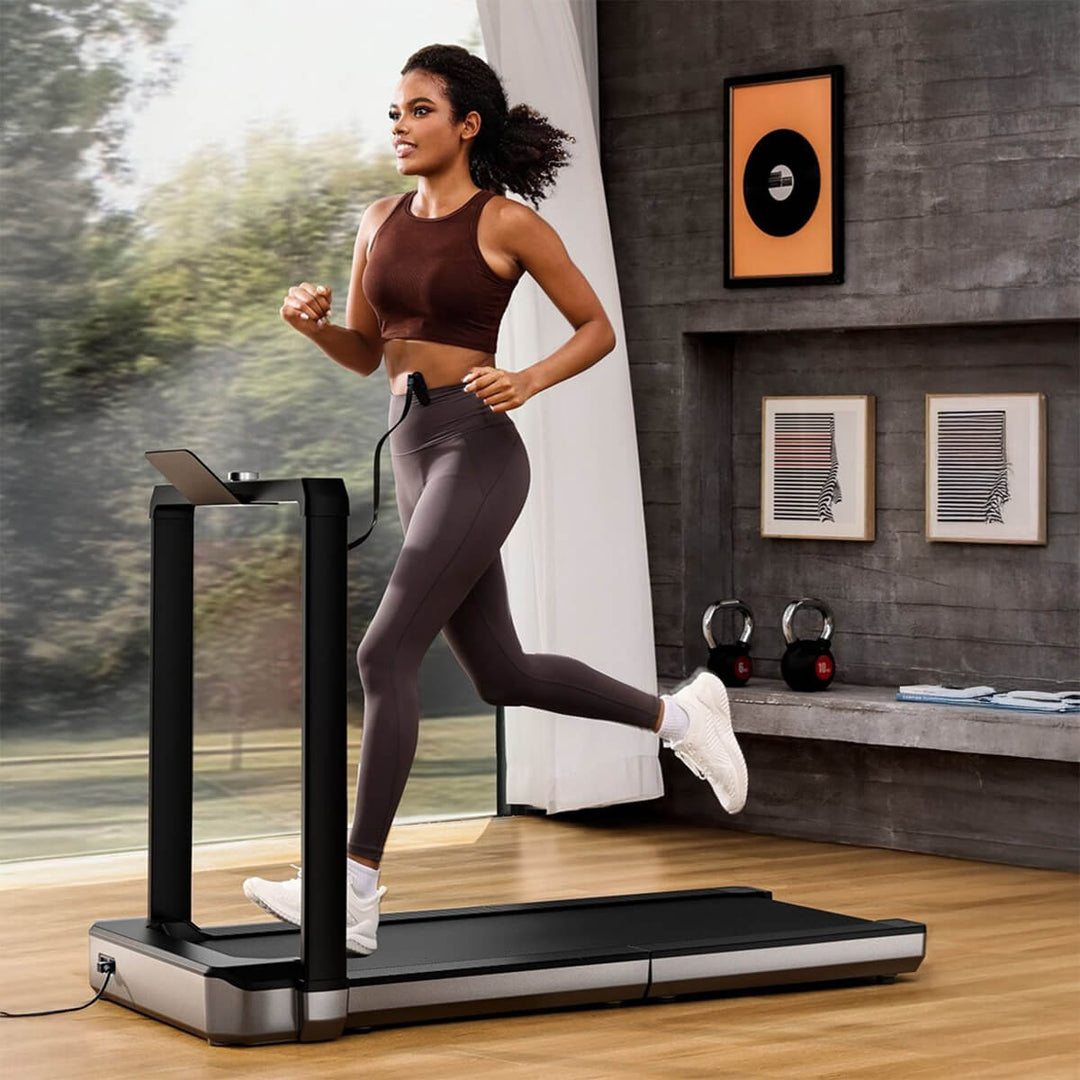 A person running on a silver and black colored walkingpad treadmill in a modern indoor setting.