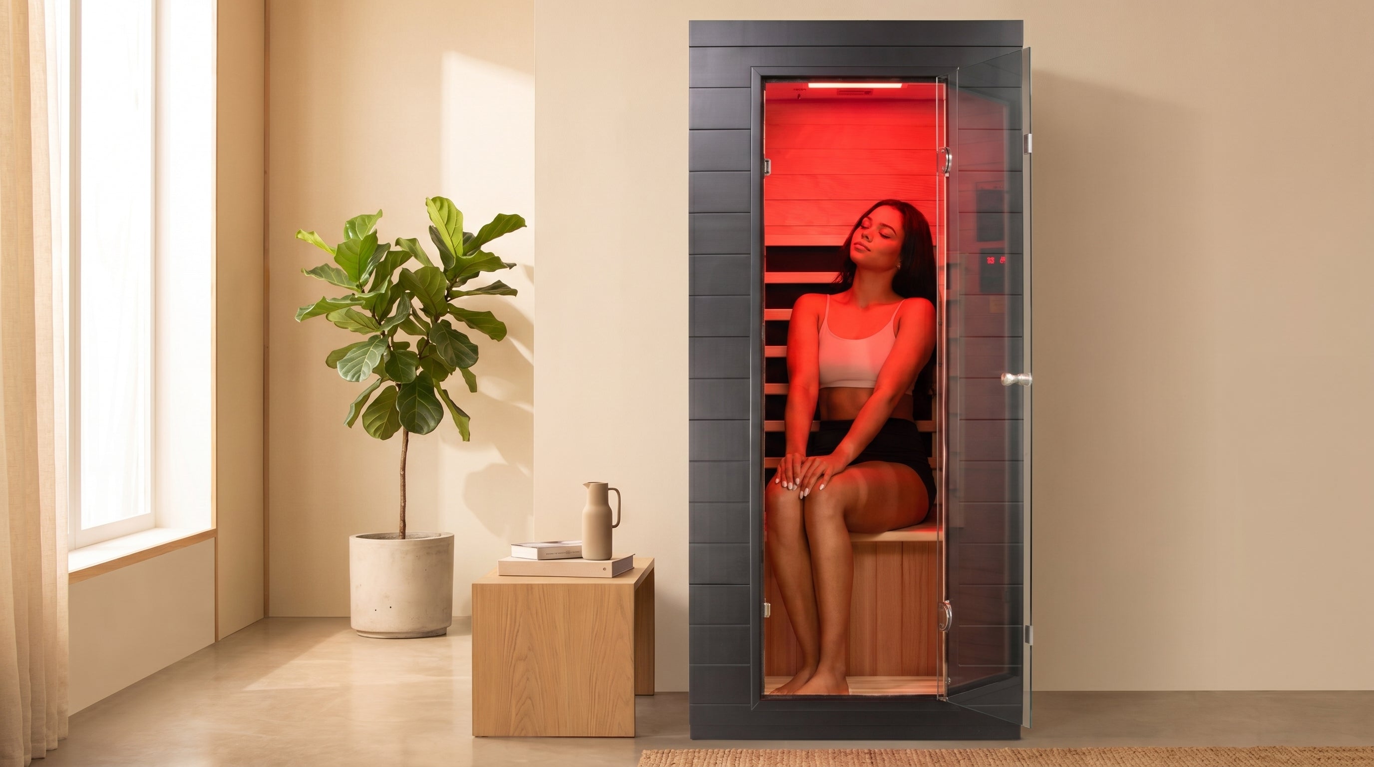 EZLIFE solo sauna 1 person infrared sauna with red light in a beautiful home with cream walls and plants.