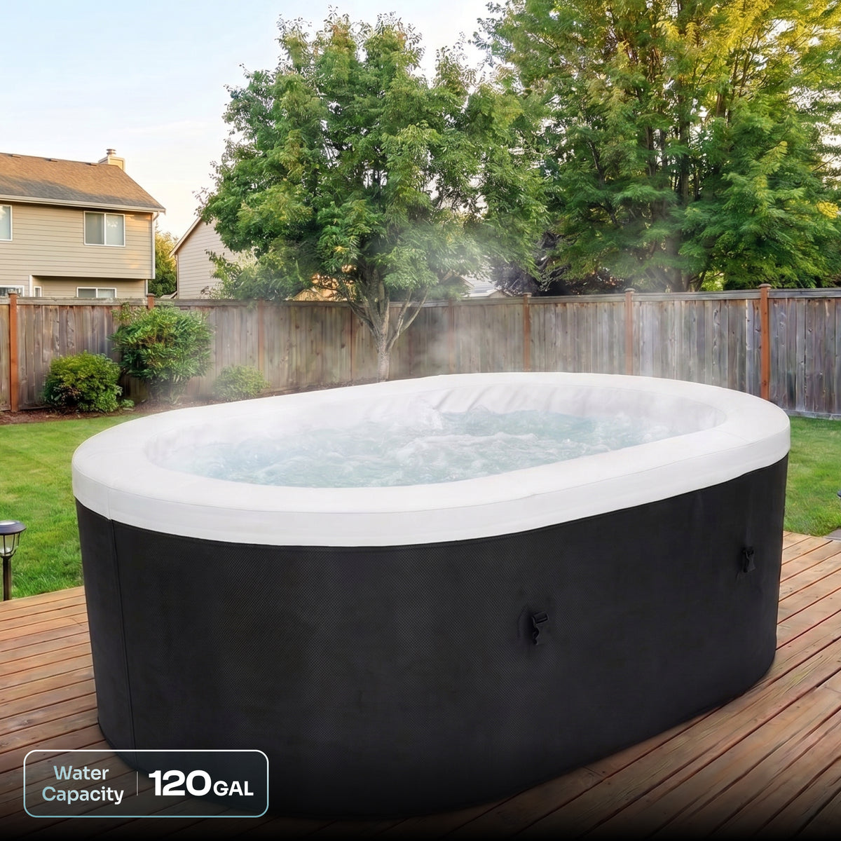 An outdoor oval hot tub with a black exterior and white interior rim, shown on a wooden deck in a backyard with trees and a fence. Steam is rising from the water, and a text overlay in the lower left reads 'Water Capacity 120 GAL'.

