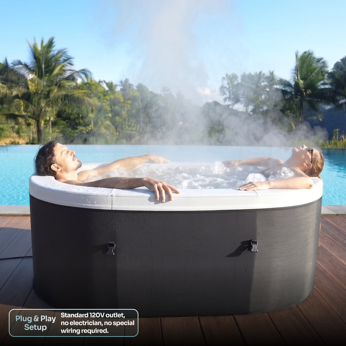 An outdoor hot tub with two people relaxing inside, surrounded by steam, set on a wooden deck next to a swimming pool with palm trees in the background.

