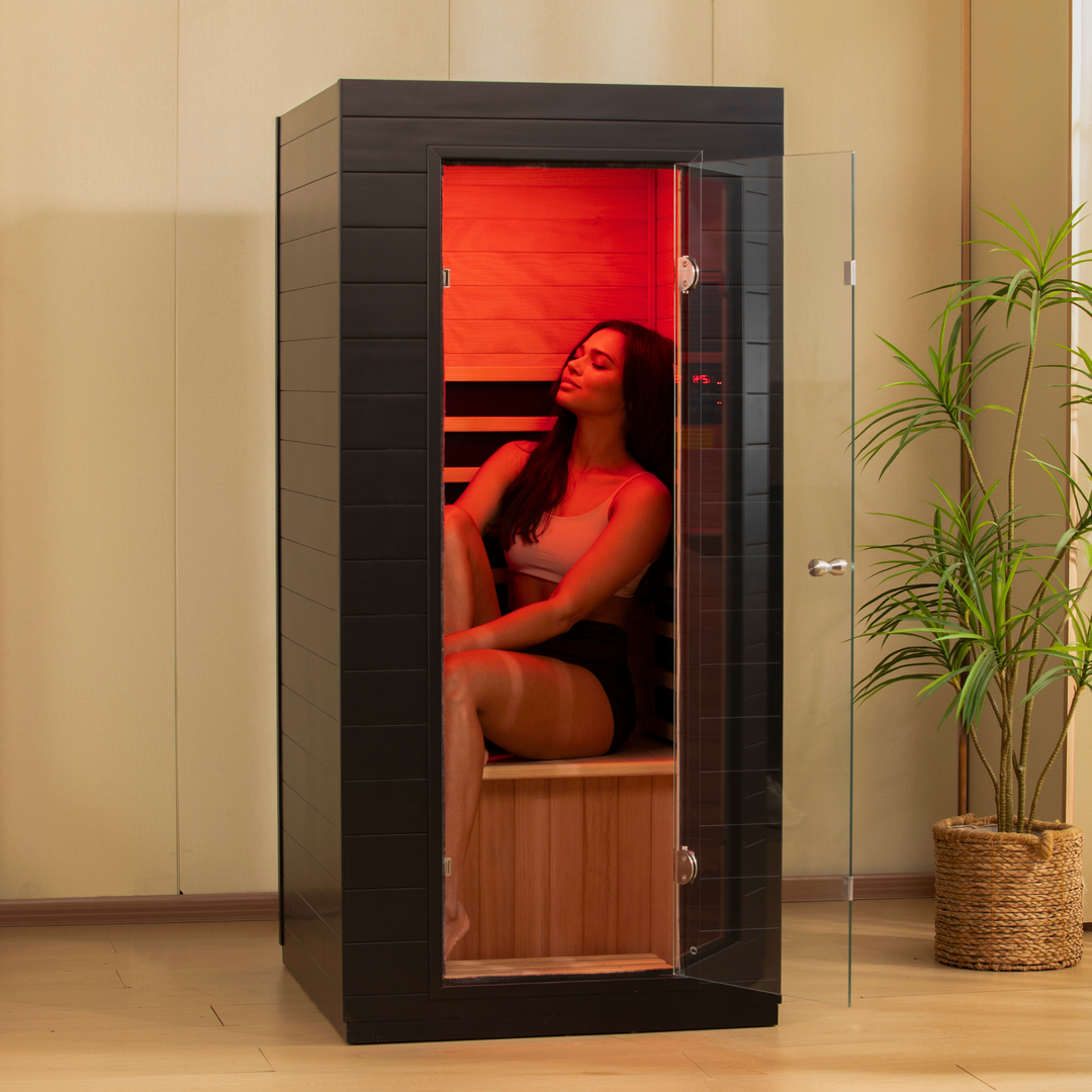 Person relaxing inside the EZLIFE Solo infrared sauna with red light