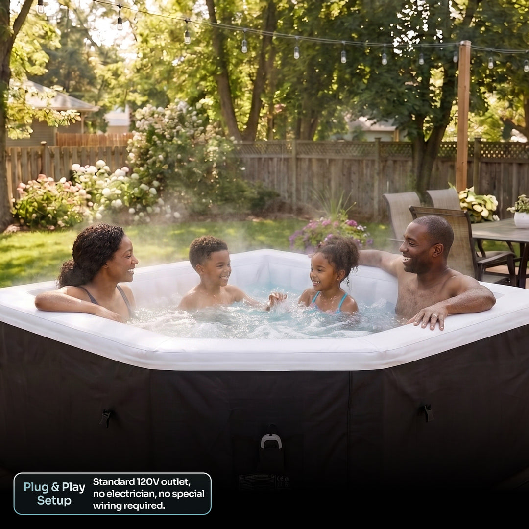 A family of four enjoys a hot spring outdoor tub in a backyard setting. The tub has a black exterior cover and a white interior, with bubbling water creating a misty atmosphere.