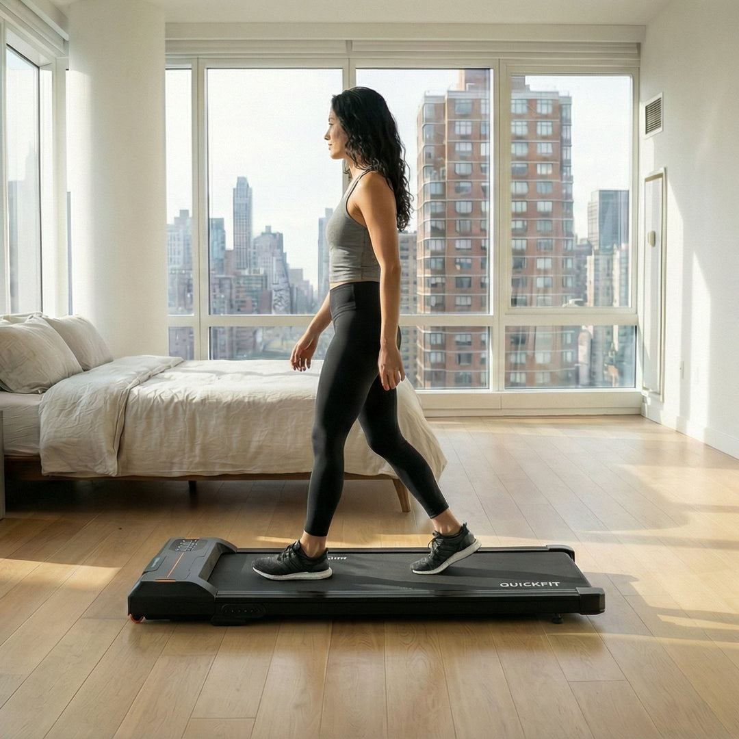 Woman using a step machine walking pad treadmill in a modern bedroom with cityscape view