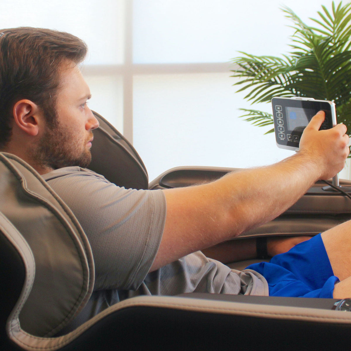 Man using Lifesmart Nova 4D Faux Leather Zero Gravity Massage Chair R8658L console.