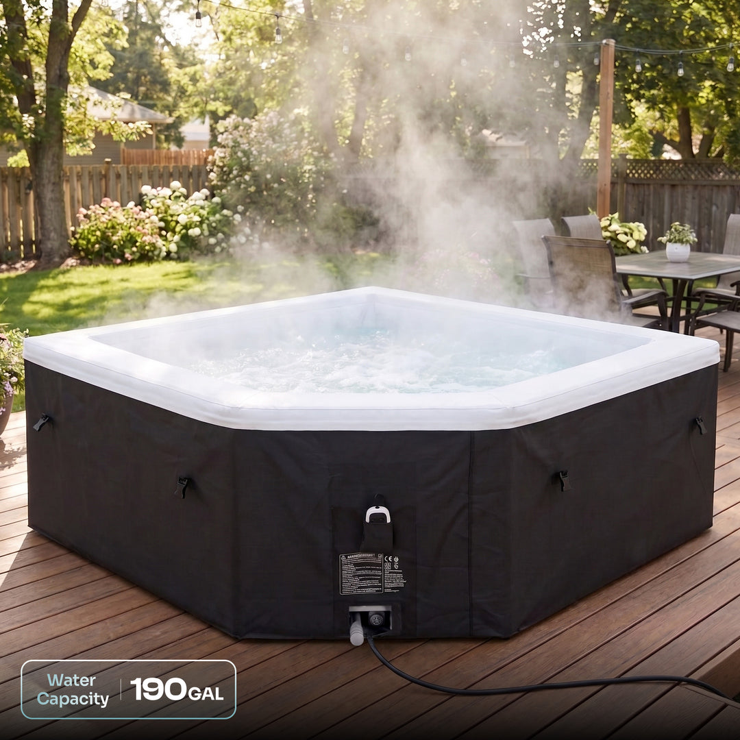 A hot tub with a black exterior cover and white interior rim sits on a wooden deck outdoors, with steam rising from the bubbling water. Trees, lawn, fence, patio furniture, and a small 'Water Capacity 190 GAL' label are visible in the scene.