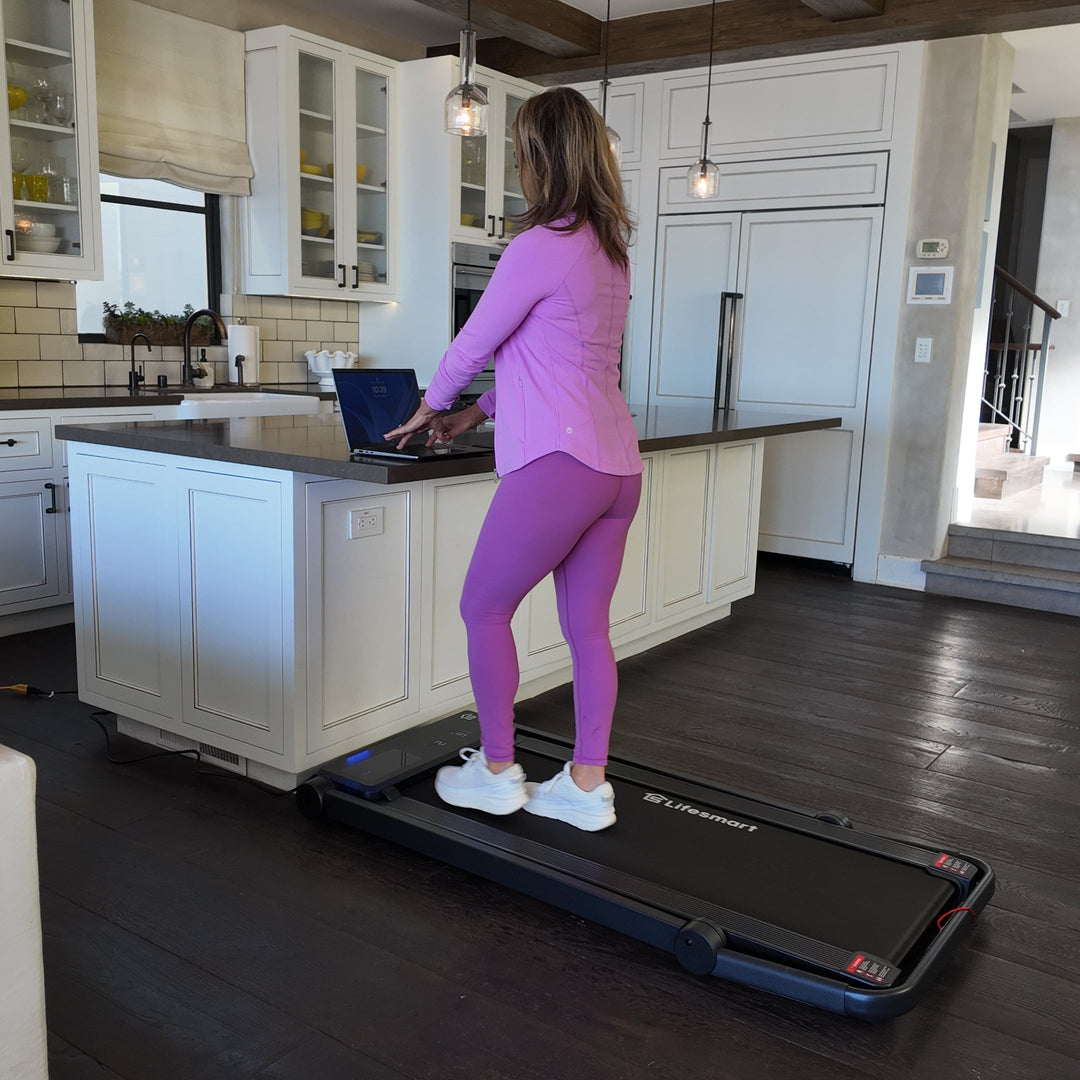 Woman using TM2202 treadmill in walking pad mode