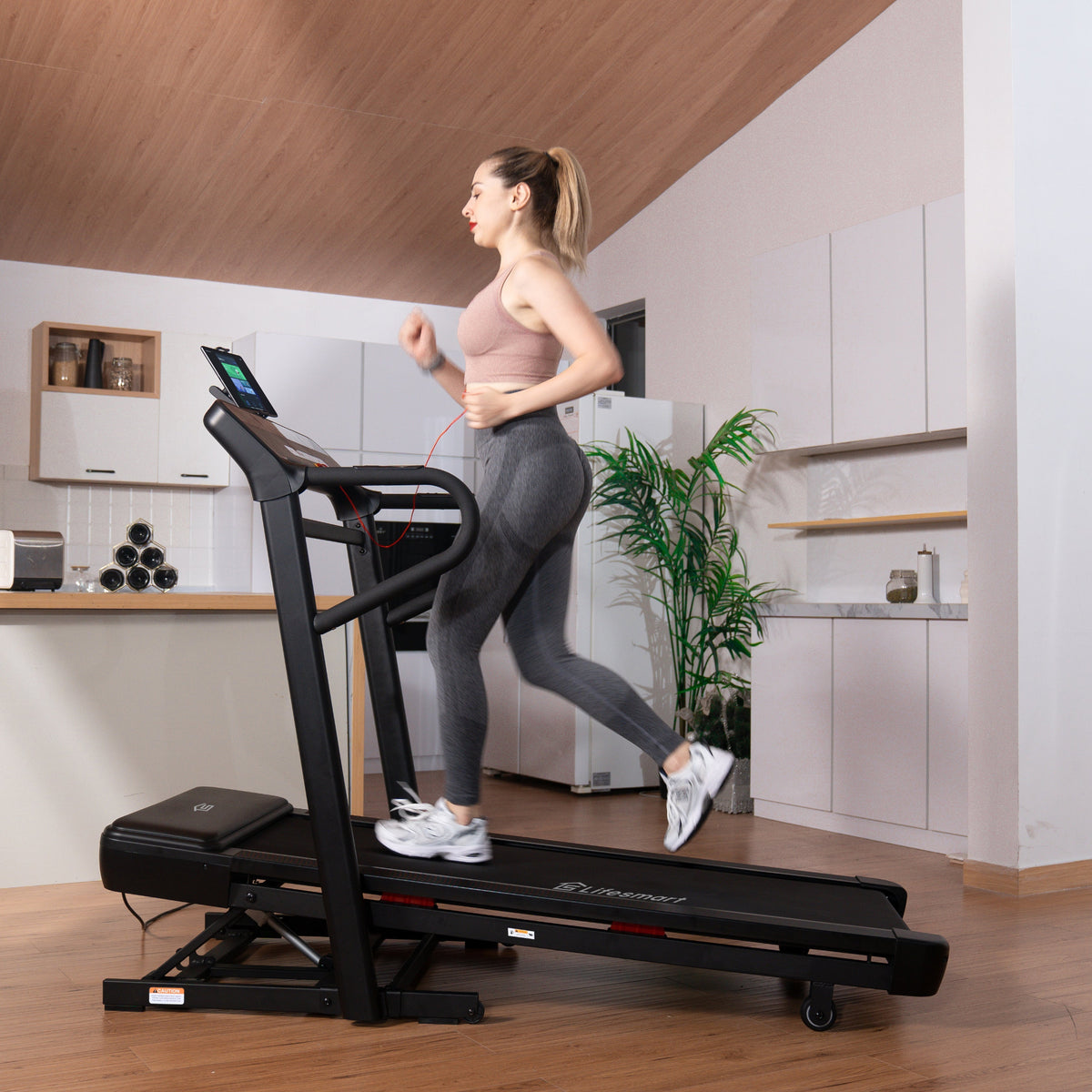 Woman jogging on Lifesmart Treadmill with Power Incline TM2303 in home living room, treadmill is inclined. 