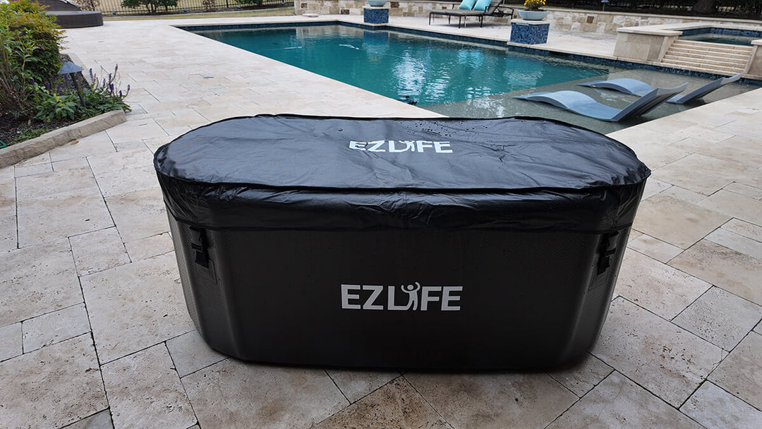 Inflatable cold plunge on patio setting with pool in background. A cover is on the cold plunge.