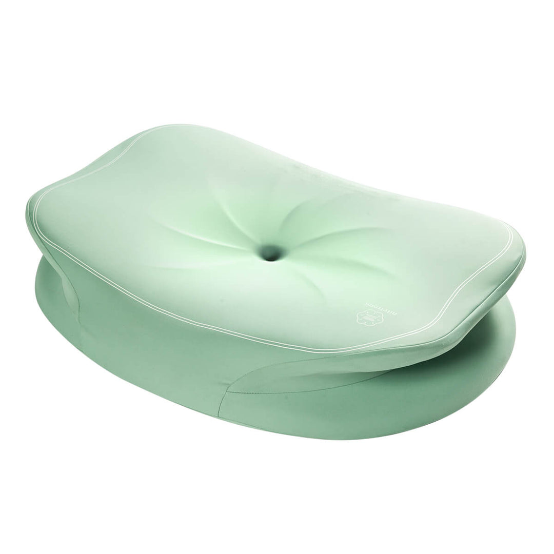 A studio lit product photo of a light green cervical neck pillow. On a white background.