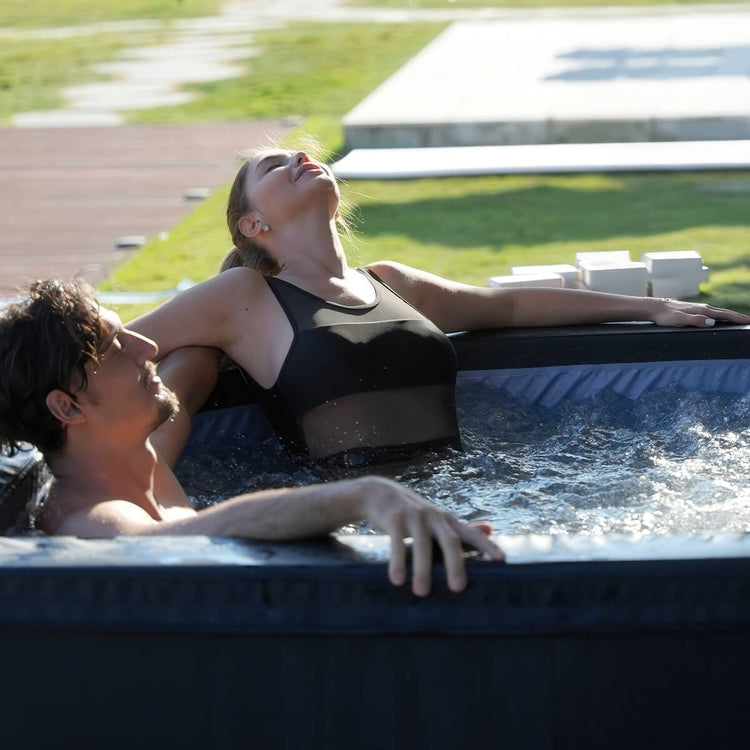 A couple relaxing in bubbling water hot tub, woman in focus.