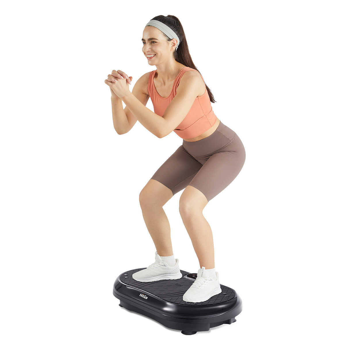 Woman exercising on vibration plate. Image isolated on white background.