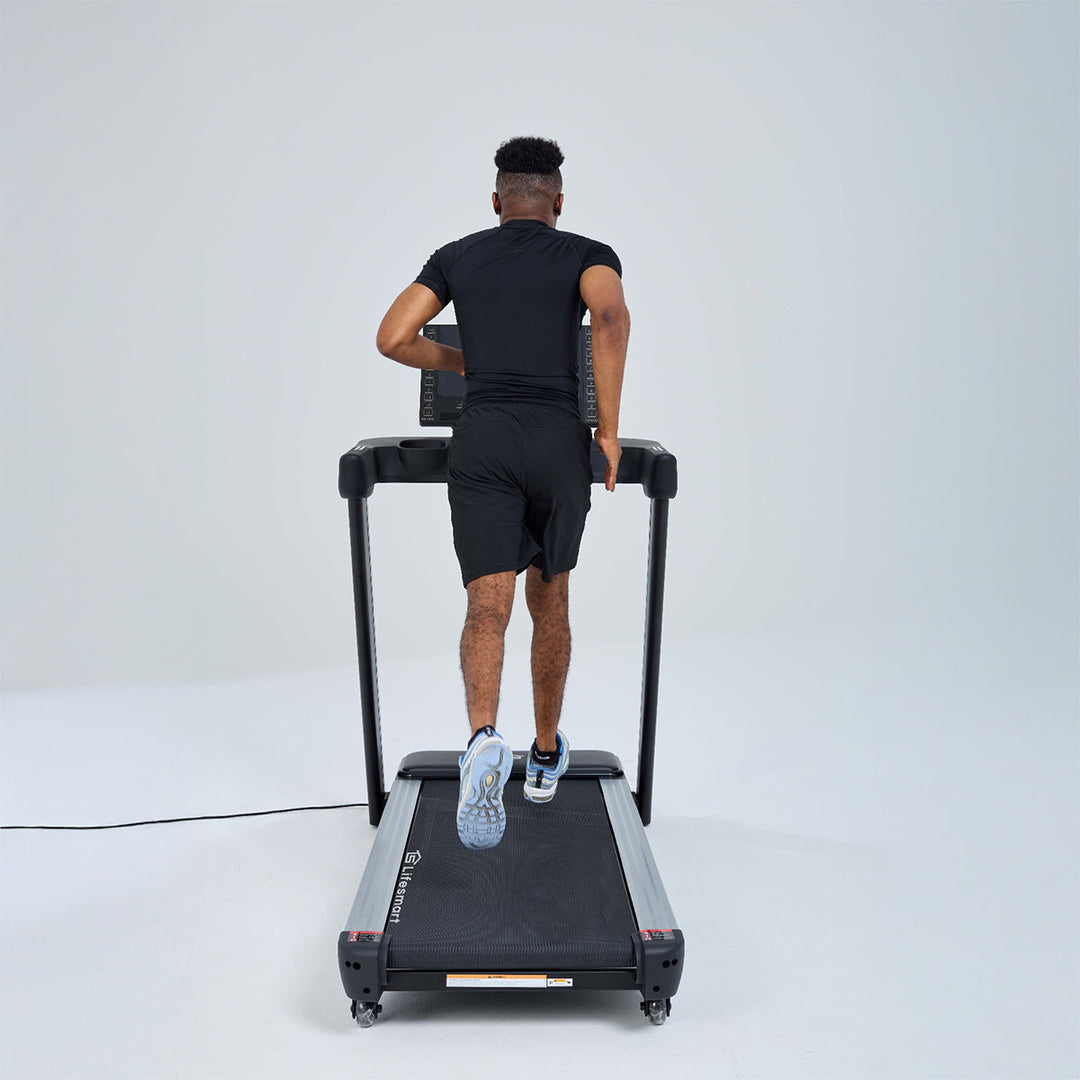 Man running on treadmill. Image angled behind treadmill.