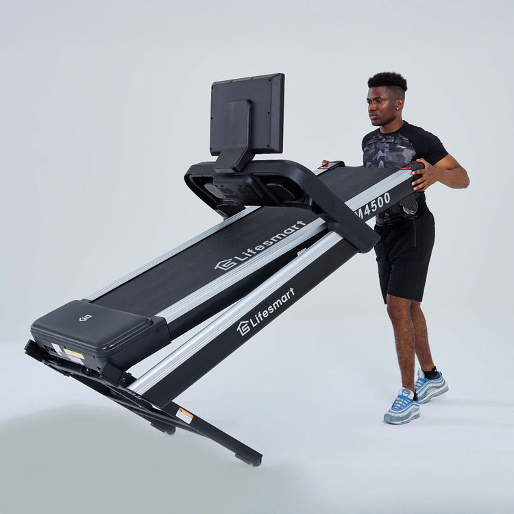 Treadmill is folded and tilted, being moved by a man.