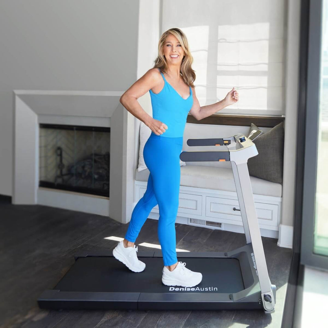 Denise Austin walking on the WalkingPad Treadmill in a home setting.