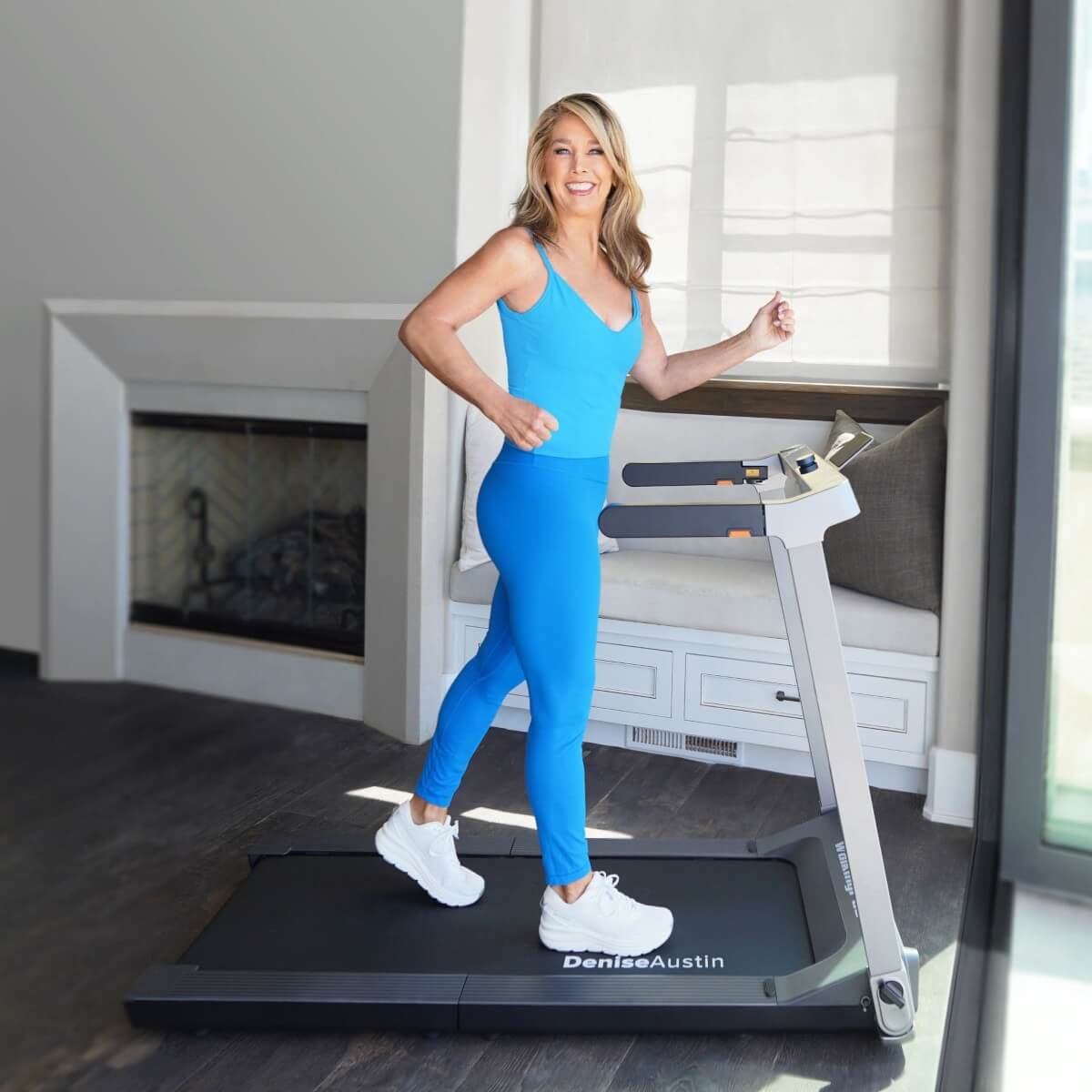 Denise Austin walking on the WalkingPad Treadmill in a home setting.